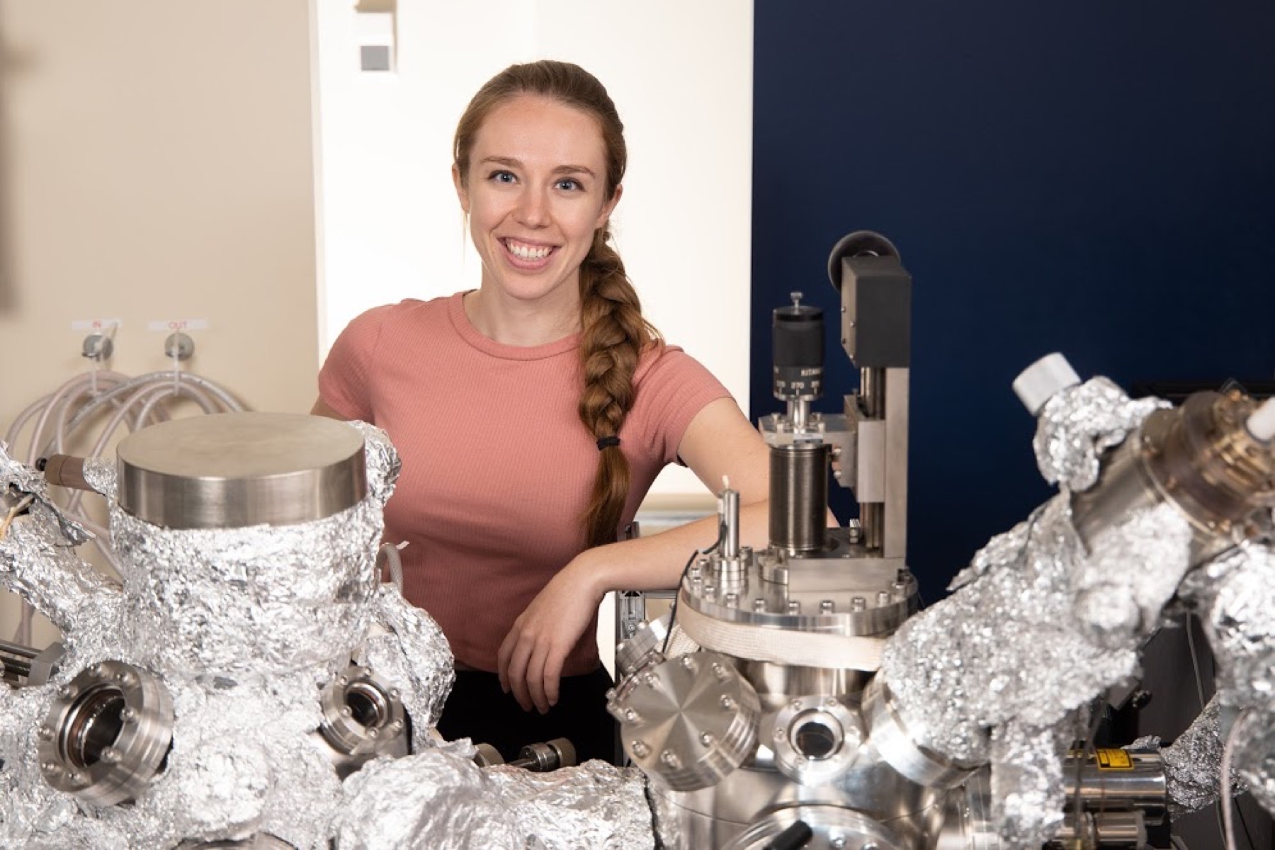 Megan Cowie standing beside an ultrafast atomic force microscope